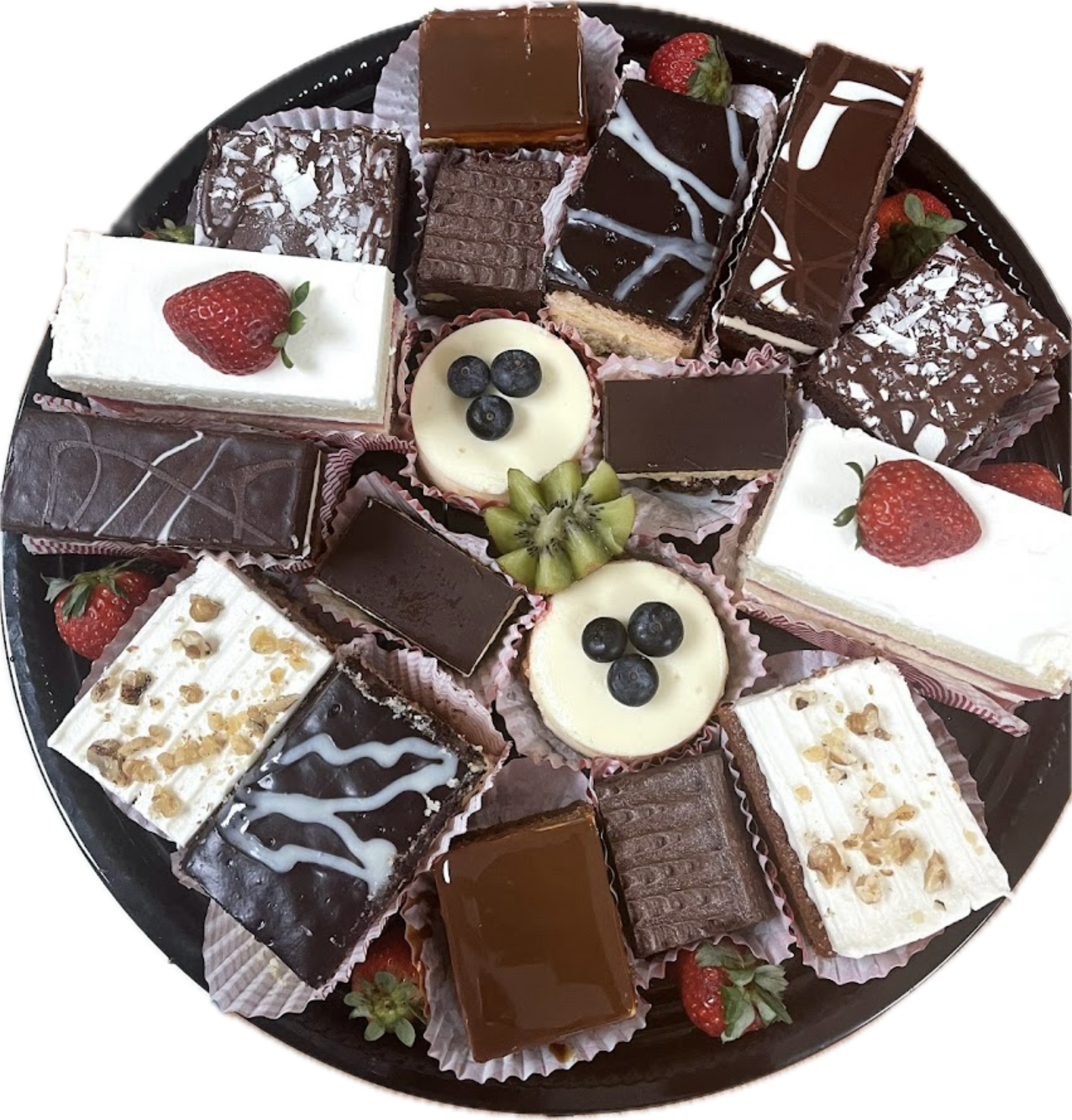 Assorted pastry platter with chocolate-glazed squares and fruit-topped mini cakes